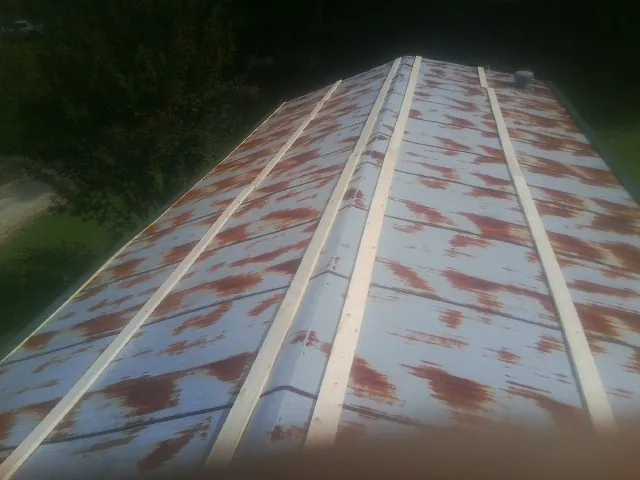 Rusted metal roof panels with new wood purlins before replacement — Storm Damage Roof Repair in Elkhart by Roofing Brothers